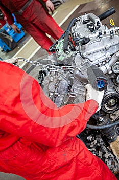 A car mechanic repairs an engine in a car service.