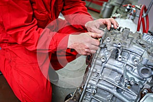 A car mechanic repairs an engine in a car service. photo