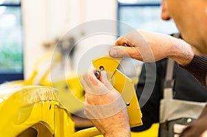 Car mechanic screws car parts together again after restoration - Serie Repair Workshop