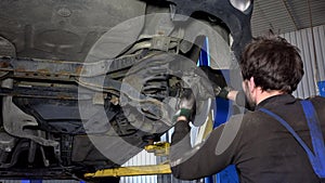 Car mechanic with spanner tool strengthen brake system.