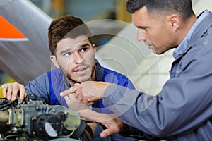 Car mechanic testing car engine in repair garage