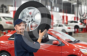 Car mechanic with a tire.