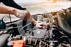 The car mechanic uses a wrench to open the car`s engine box