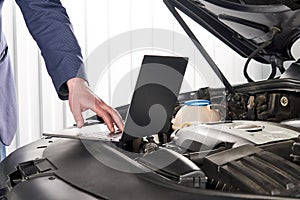 Car mechanic using computer in auto repair shop