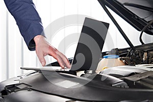 Car mechanic using computer in auto repair shop