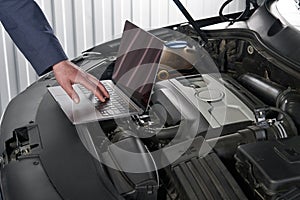 Car mechanic using computer in auto repair shop