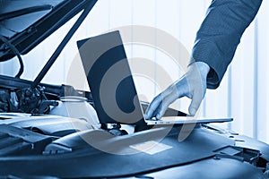 Car mechanic using computer in auto repair shop