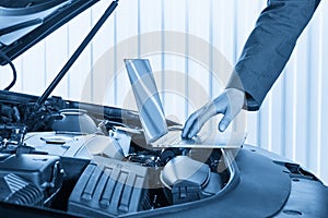 Car mechanic using computer in auto repair shop