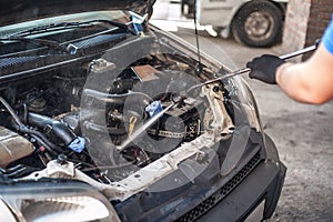 Car mechanic washes the car engine with pressurized water