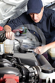 Car mechanic working in auto repair service.