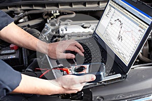 Car mechanic working in auto repair service.