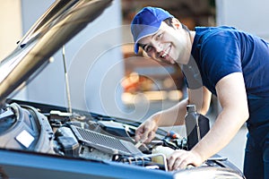 Car mechanic working in auto repair service.