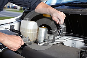 Car mechanic working in auto repair service.