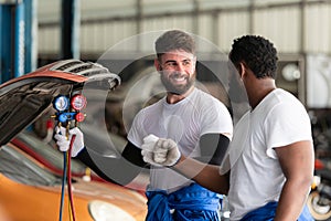 Car mechanic working in an auto repair shop, inspecting the operation of the car\'s air conditioner