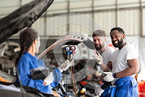 Car mechanic working in an auto repair shop, inspecting the operation of the car\'s air conditioner