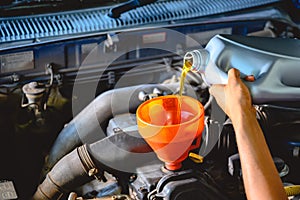 Car mechanic working in a car repair shop Pour the engine oil to change the engine oil in the garage for customers who use it Car