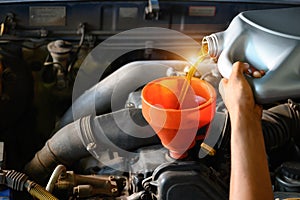 Car mechanic working in a car repair shop Pour the engine oil to change the engine oil in the garage for customers who use it Car