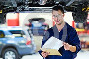 Car mechanic working on the underside of a car