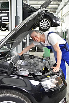 car mechanic in a workshop - engine repair and diagnosis on a vehicle