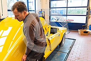 Car mechanics align the bonnet correctly when assembling - Serie Repair Workshop