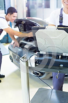 Car mechanics with diagnosis tool in Asian auto workshop