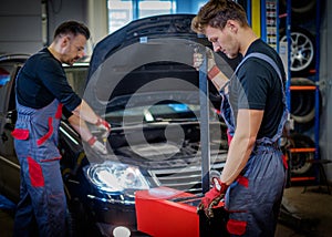 Car mechanics inspecting headlights in a workshop