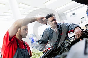 Car mechanics working at automotive service center