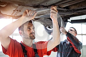 Car mechanics working at automotive service center