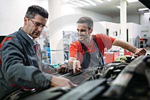 Car mechanics working at automotive service center