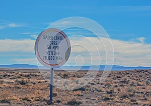 Car and Meteor speed limit sign. On the road to the Meteor Crater Natural Monument on the Arizona Rocky Plain