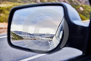 Car Mirror and reflection of the road and sky in it