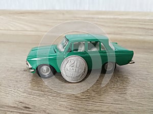 Car model toy in comparison with old coin