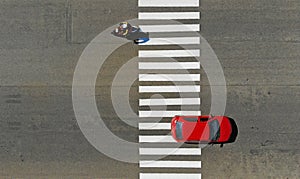 Car and motorcycle crossing a pedestrian crosswalk zebra on a highway
