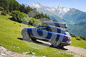 Car in mountains. Car is an off-road car in mountain on clear, sunny summer day. Travel by car through the wild