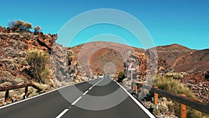 Car moves on an asphalt new road comes into a turn. inside view. Outside the desert on a volcanic island. Mountain peak