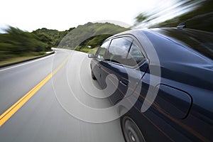 The car moves at great speed at the mountain road