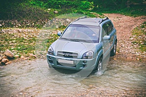 Car moves through mountain river