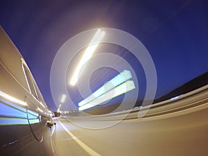 The car is moving at high speed on the night city road.