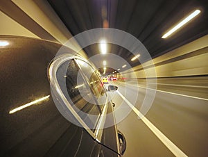 The car is moving at high speed on the night city road.