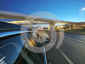 The car is moving at high speed on the night road in the city.