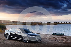 Car near river and boat at sunset summertime audi