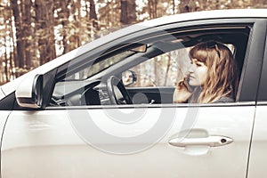 Car with an open window and a girl with a phone inside