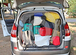 Car overloaded with suitcases and duffle bag