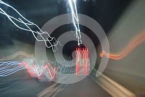 Car overtakes truck inside the highway tunnel. Wavy light trails effect in color.