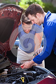 Car Owner With Mechanic Testing Car Battery
