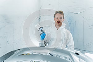 Car painter with painting gun in chamber.