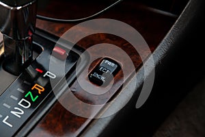 The car panel is next to the speed switch with letters designating the gears and the transmission control buttons and the