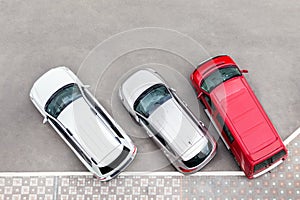 Car parked in aprking area at city street. Vehicles stand in row near road. View from above