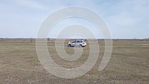 Car is parked in a dry field