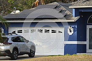 Car parked in front of wide garage double door on concrete driveway of new modern american house
